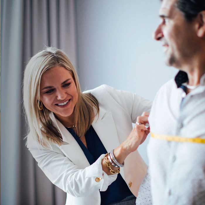 A Tom James clothier measuring a client's chest.